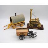 A brass model 'Stephens Rocket', along with a wooden model shepherds hut and a bakers bike