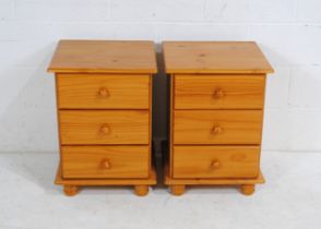 A pair of modern pine bedside chests, each with three drawers, raised on turned feet - length
