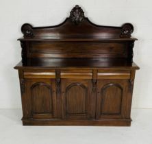 A Victorian style mahogany chiffonier with scrolling raised panel above three drawers and cupboard