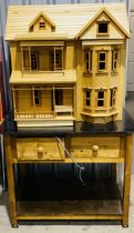A large modern wooden American style dolls house, with a purpose-built stand in the form of a