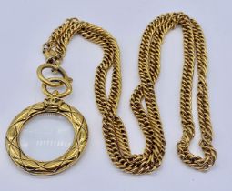 A Chanel magnifying glass necklace, circa 1970/80, the gold textured glass loupe pendant on a