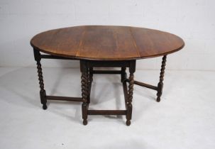An antique oak gateleg table, with barley twist supports