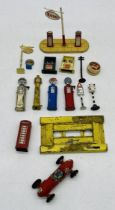 A collection of die-cast petrol pumps including Esso, along with a few road signs, traffic lights