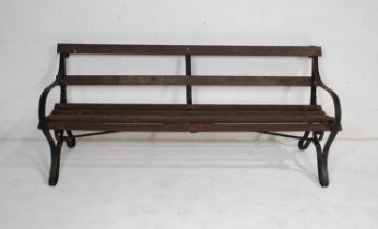 A large wrought iron garden bench with wooden slatted seat - length 184cm