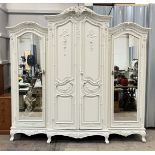 A French classical style white painted triple wardrobe, with mirrored doors and ornate detailing -
