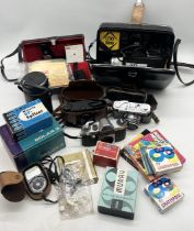 A collection of various vintage cameras and video cameras with accessories including Canon Super