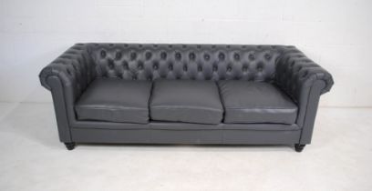 A modern grey leather Chesterfield sofa, raised on turned feet - length 217cm