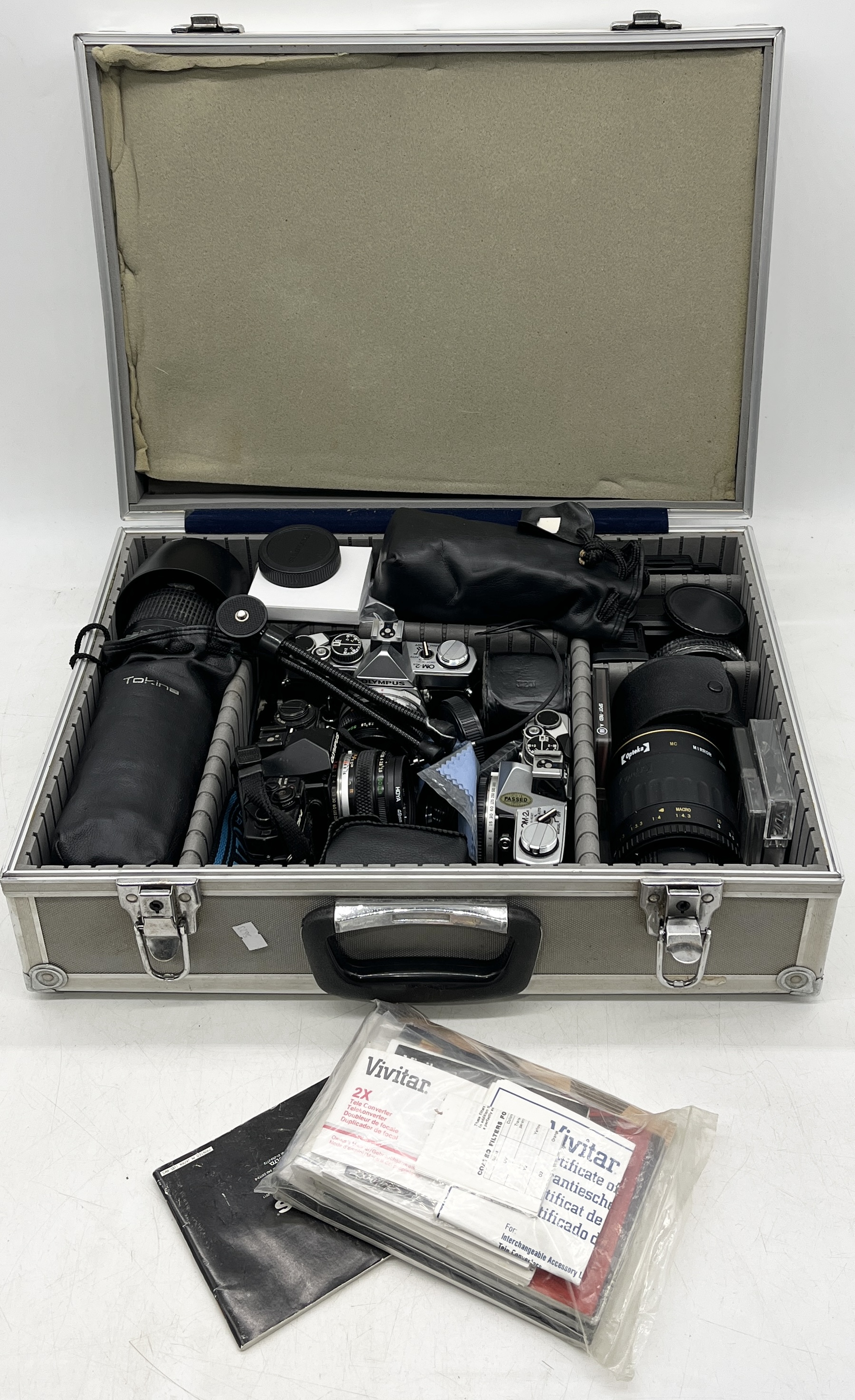 A cased collection of cameras, lenses and accessories including Olympus OM-2, Olympus OM-4 etc.