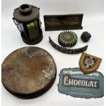 A collection of various items including a coloured lass lantern, wooden cogs, curved printing