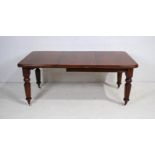 A Victorian mahogany rectangular extending dining table, with one extra leaf, raised on tapering