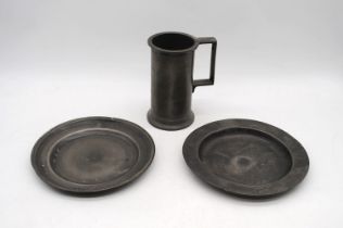 An antique pewter tankard, along with two pewter plates, with impressed marks