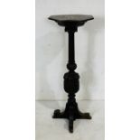 An antique oak torchere with heavy carved detailing, height 132cm