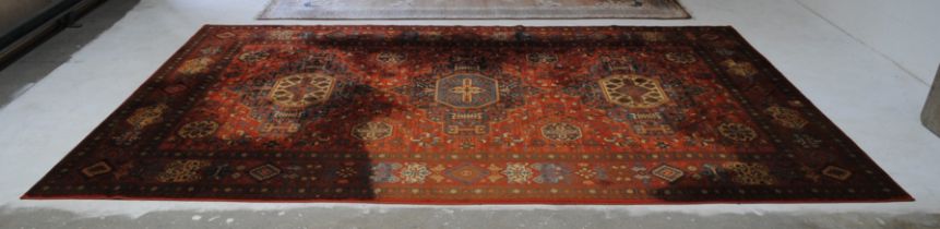 A large Eastern style red ground rug - some staining - 351cm x 251cm