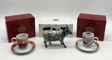 A boxed Cow Parade ceramic figurine with multi coloured design along with two boxed Goebel Rosina