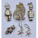 Two hallmarked silver novelty rattles, an SCM cat rattle, articulated teddy bear earrings etc.