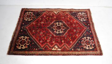 An Eastern red ground rug, with traditional designs - 173cm x 123cm