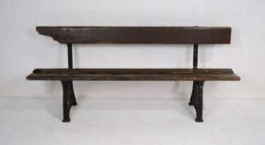 A weathered cast iron garden bench, with wooden slatted seat and back, possibly railway - length