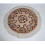 A small Chinese circular cream ground rug, with floral decoration - diameter 124cm