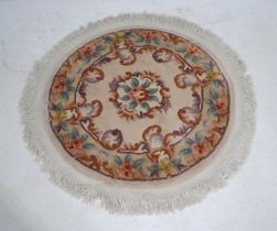 A small Chinese circular cream ground rug, with floral decoration - diameter 124cm