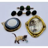 A Victorian yellow metal brooch set with a large banded agate, scarab brooches, enamelled cat brooch