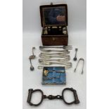 A pair of antique handcuffs (no key) along with a crocodile skin travelling dressing case (lid A/