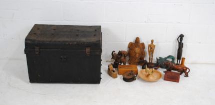 A black painted tin trunk, containing various carved wooden figures, boxes etc.