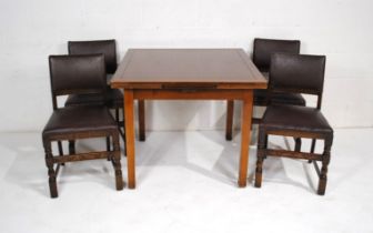 An oak draw leaf table, with a set of four upholstered oak dining chairs, with carved detailing