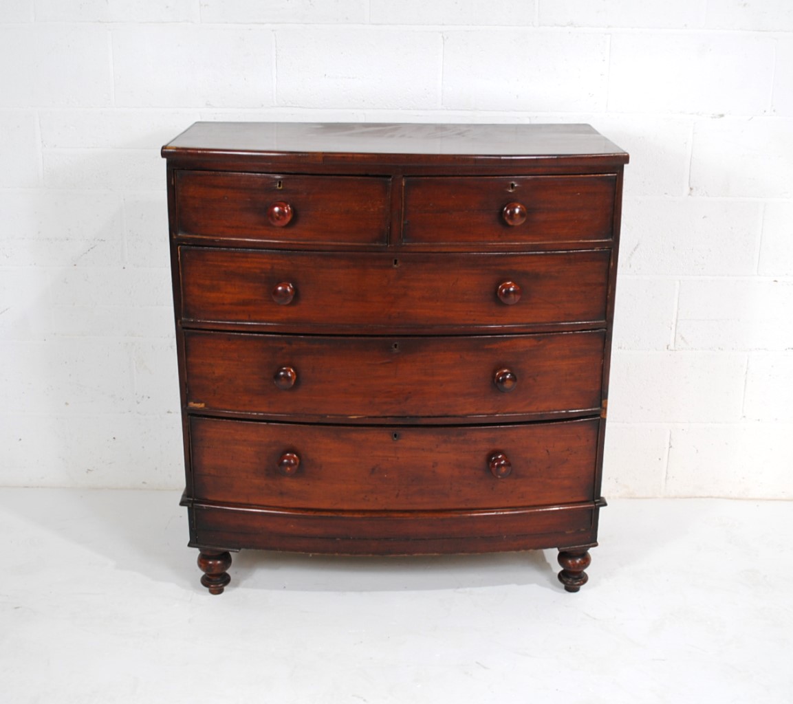 A Victorian mahogany bow-fronted chest of five drawers, raised on turned legs - one leg loose but