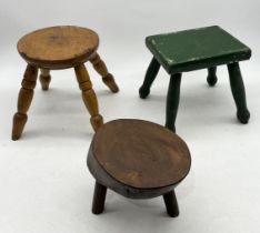 A collection of three small rustic stools