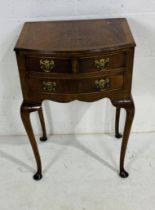 A bow fronted bedside cabinet on cabriole legs