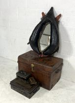 A mirror formed from a heavy horse collar along with a metal trunk and three metal boxes.