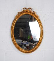 A small oval gilt framed wall mirror - 52.5cm x 37.5cm