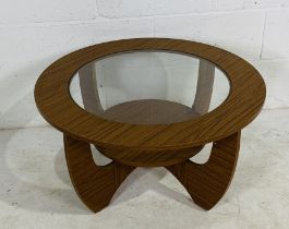 A mid-century circular coffee table with glass top