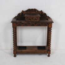 An antique oak hall stand, with storage compartment to top, with carved detailing and bobbin