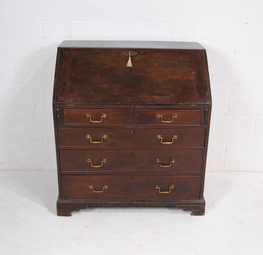 A Georgian mahogany bureau, with five drawers with brass handles, raised on bracket feet, with