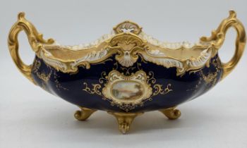 A Coalport centrepiece decorated with blue and gilt ground with hand painted panels of Hampton