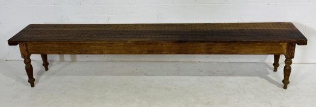 A long pitch pine bench on turned legs - length 275cm, width 46cm