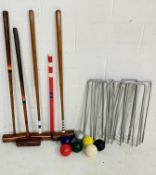 A matched croquet set to include mallets, rings, scoring pin and balls.