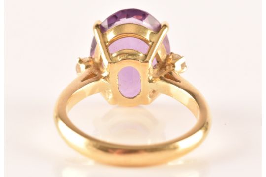 A 18ct yellow gold amethyst and diamond flanked solitaire, set with an oval cut amethyst with a - Image 3 of 7