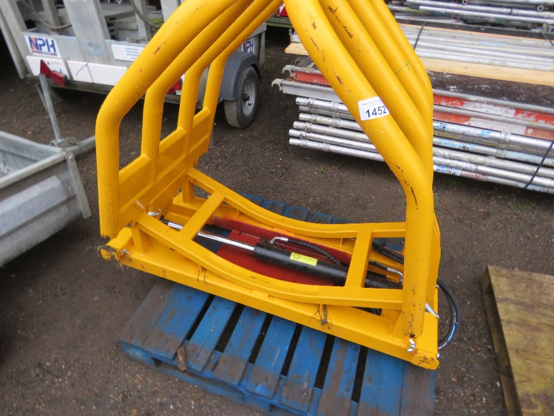 WRAPPED SILAGE BALE SQUEEZE ATTACHMENT FOR LOADER, APPEARS UNUSED.....THIS LOT IS SOLD UNDER THE AUC