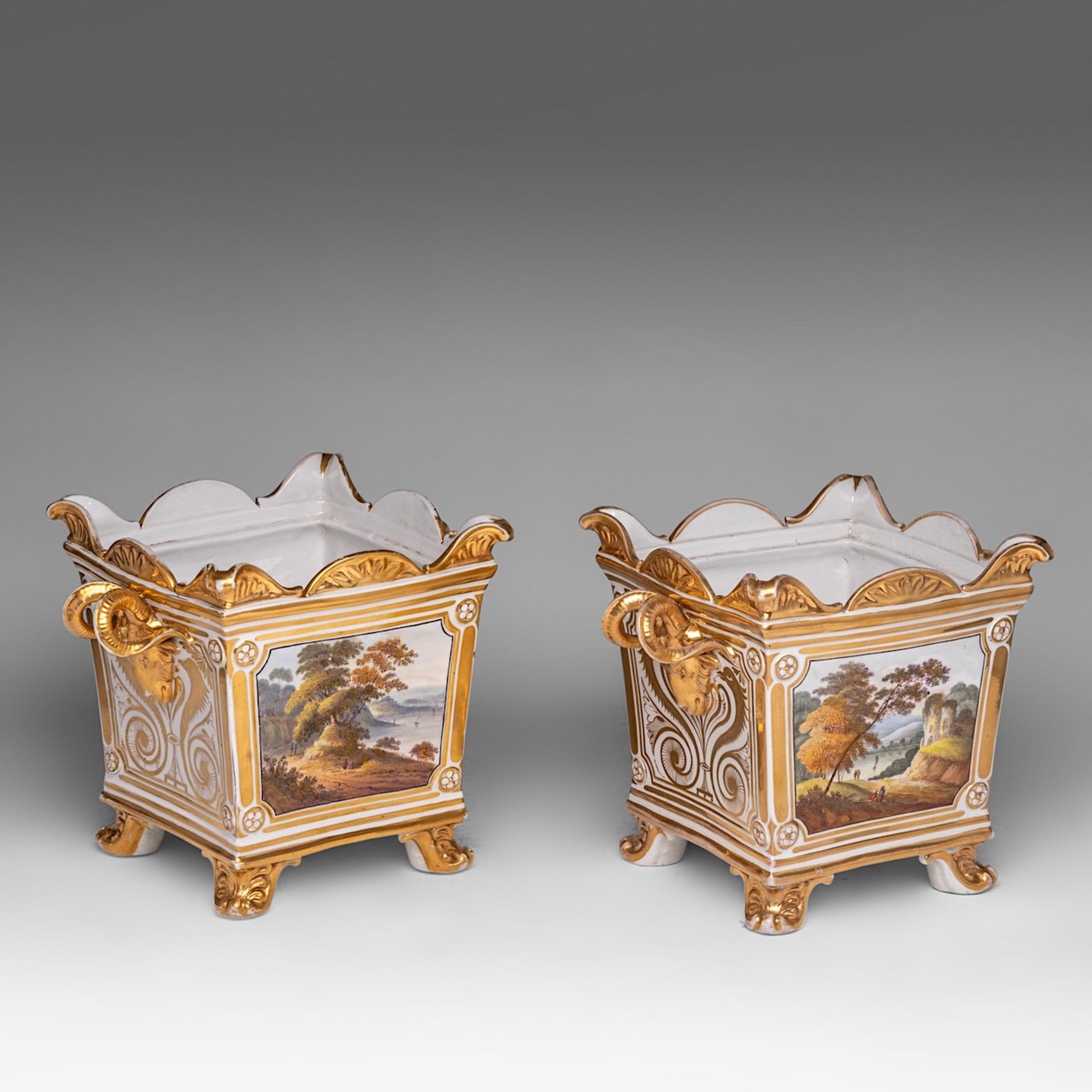 A pair of hand-painted and gilt-decorated porcelain jardinieres with landscapes and flowers, 19thC,