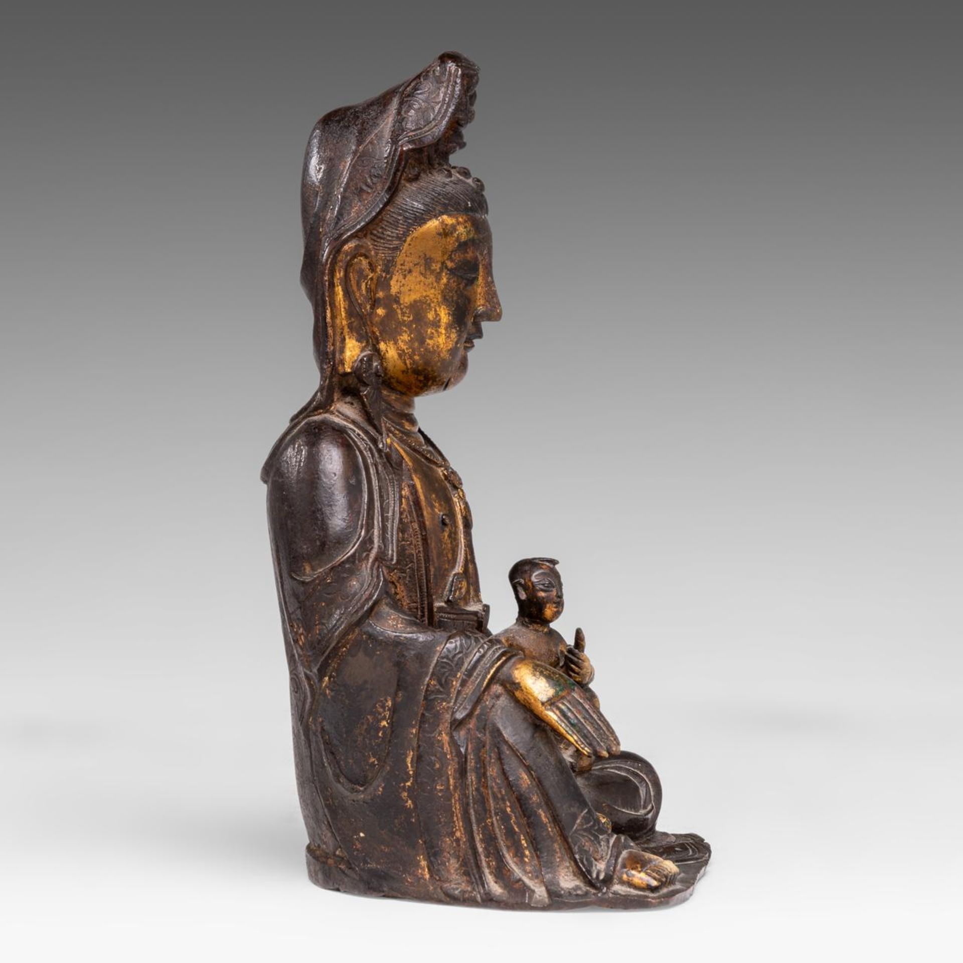 A Chinese gilt bronze figure of seated Bodhisattva Avalokiteshvara (Songzi Guanyin), late Ming, H 22 - Image 6 of 8