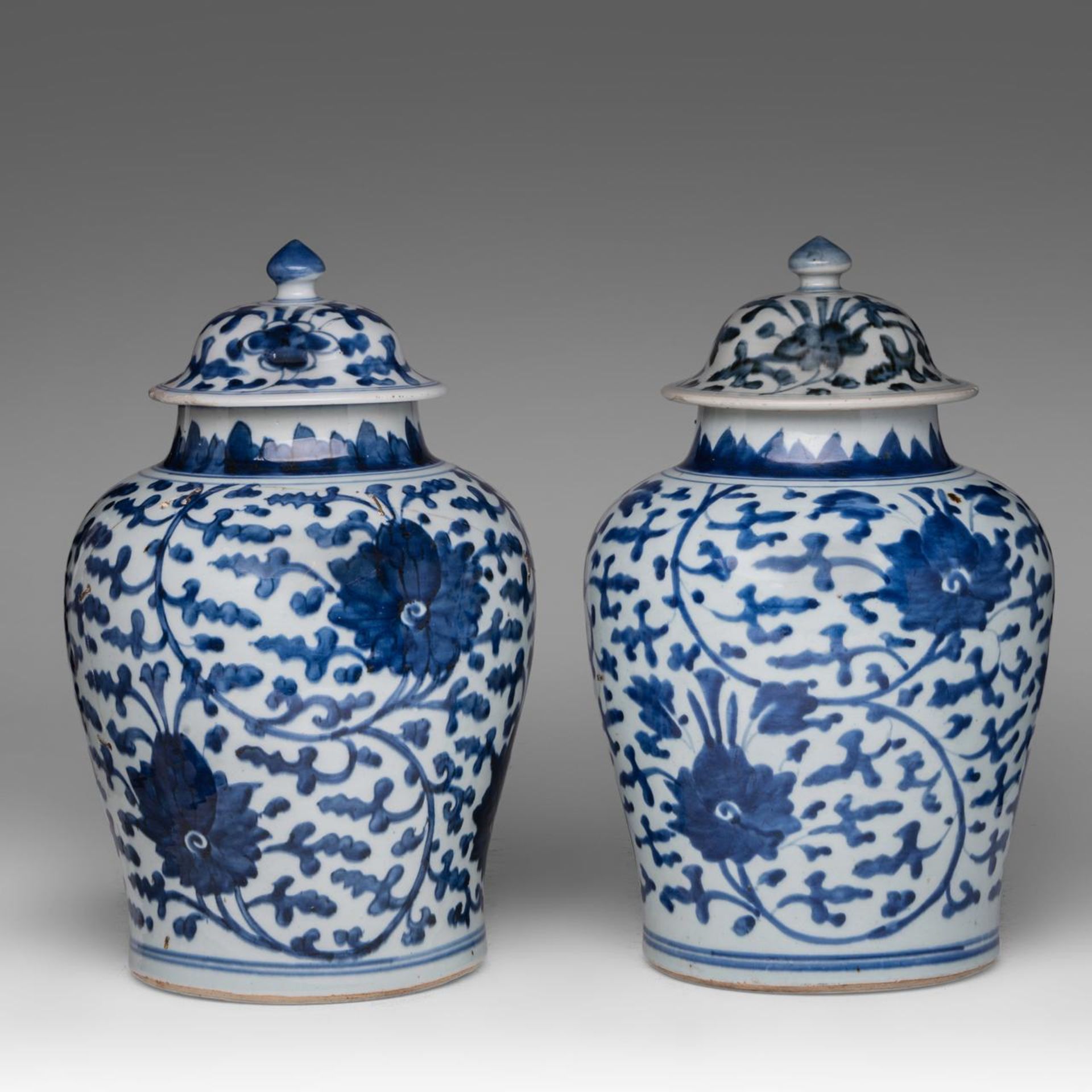 A pair of Chinese blue and white 'Scrolling Lotus' baluster vases and covers, early Qing, H 37 cm