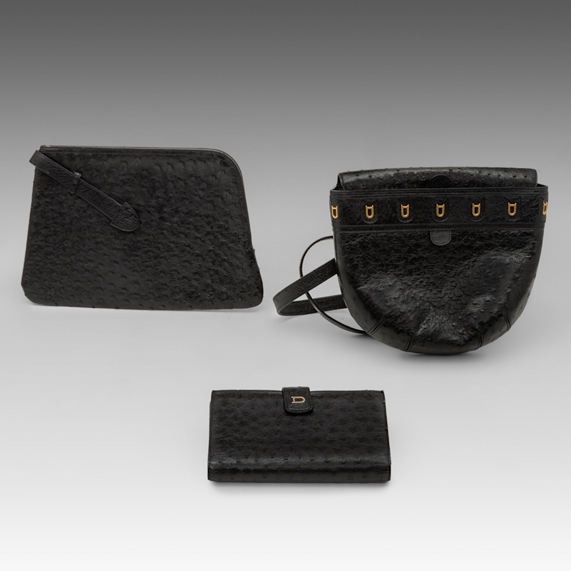A matching collection of a Delvaux shoulder bag, a clutch and a wallet in black ostrich leather.
