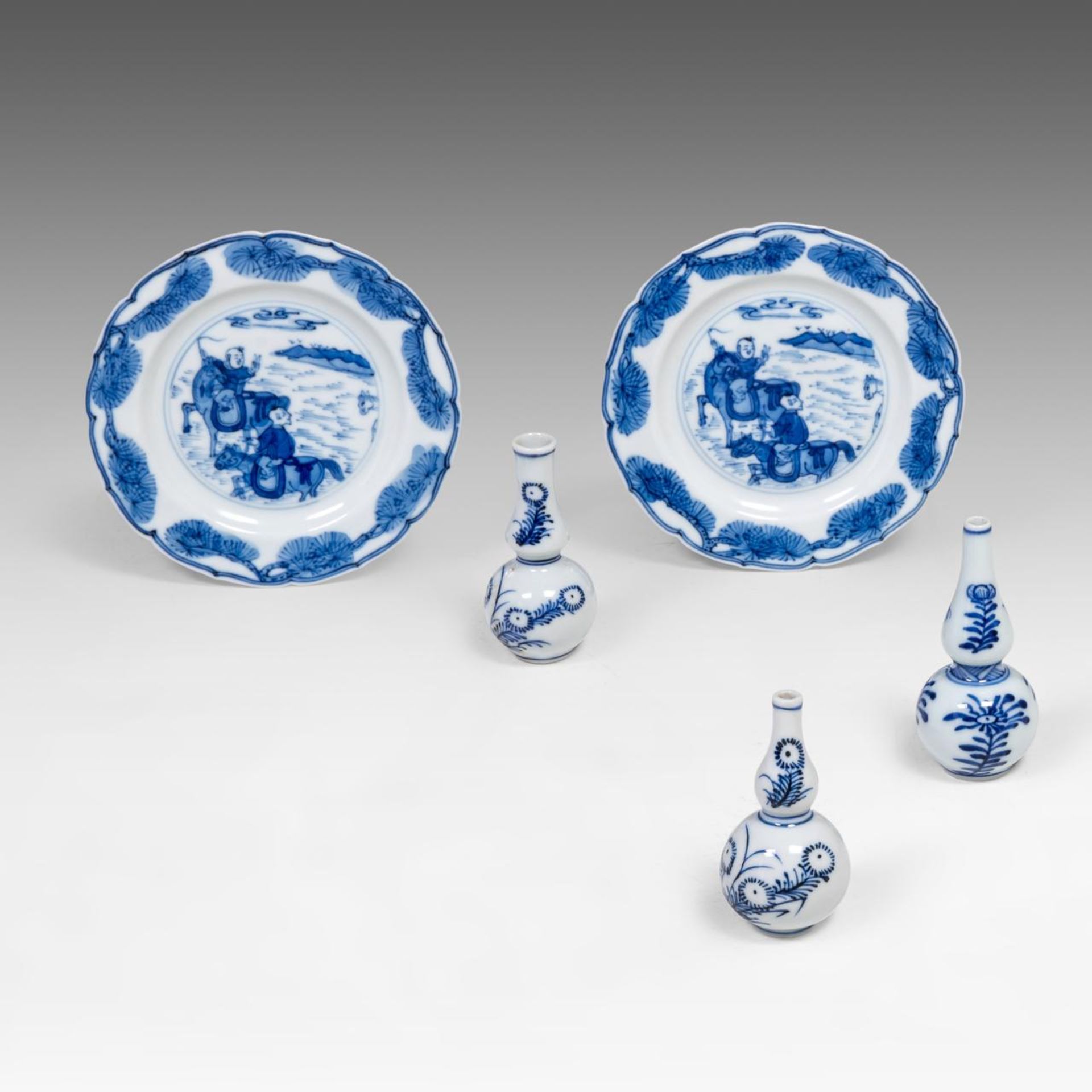 A pair of Chinese blue and white 'Hunting' saucers, Kangxi period, dia 10,8 cm - added three blue an
