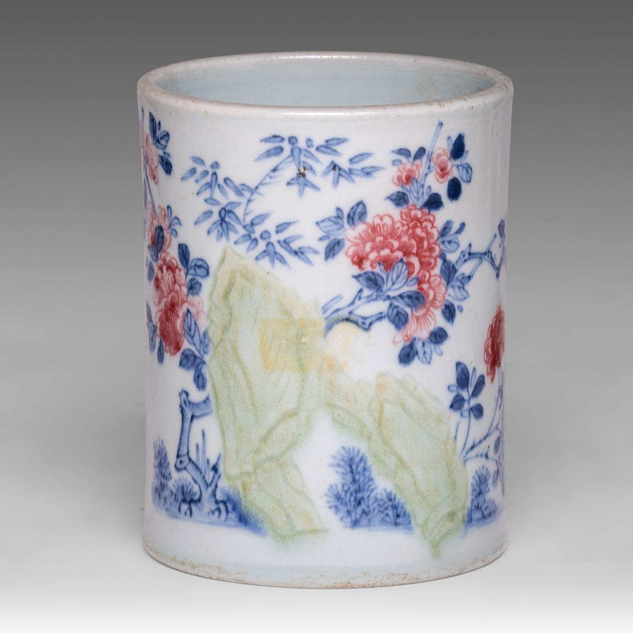 A Chinese blue and white and copper red 'Peony garden' brush pot, H 25,5 cm