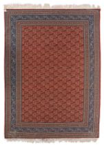 A large Persian woollen rug decorated with paisley motifs, 337/349 x 464 cm