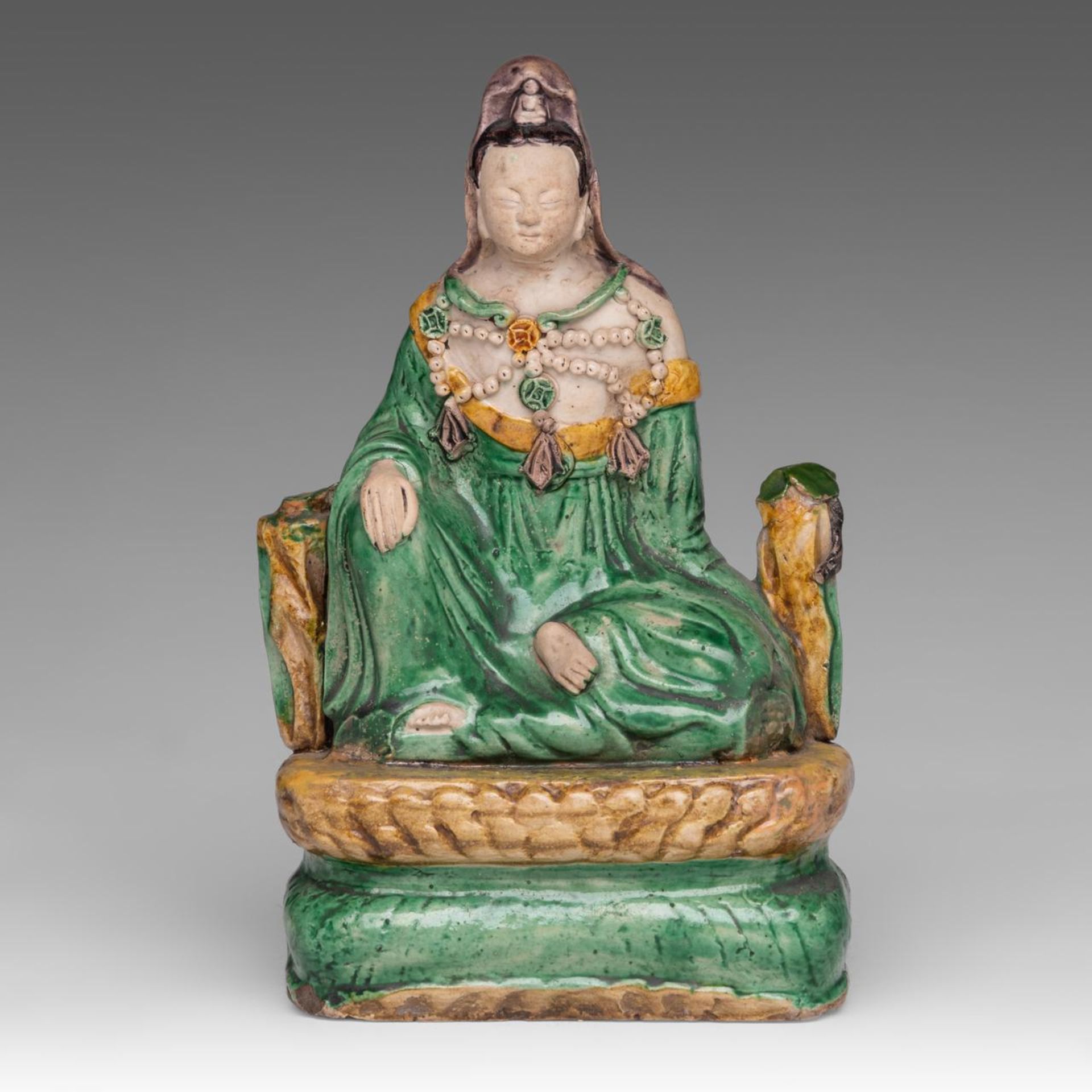 A Chinese sancai-glazed biscuit figure of seated Guanyin, late Ming, H 23 - L 14 cm