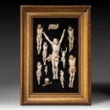 A collection of ivory corpus Christi on a black velvet background, framed 38x54 cm (+)