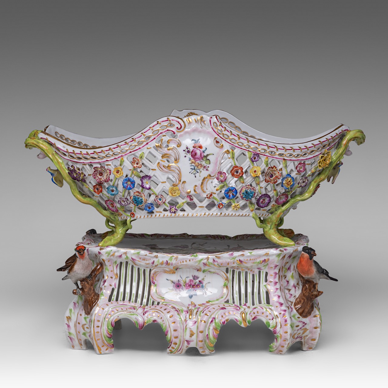 A polychrome Saxony porcelain basket on stand, decorated with modelled birds and flowers, H 33 - W 4